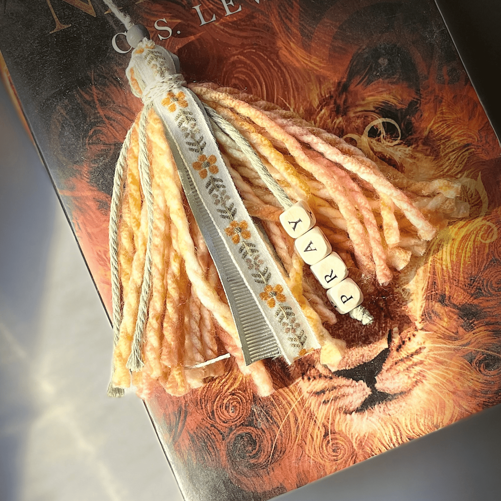 Pray Bookmark Tassel on a book