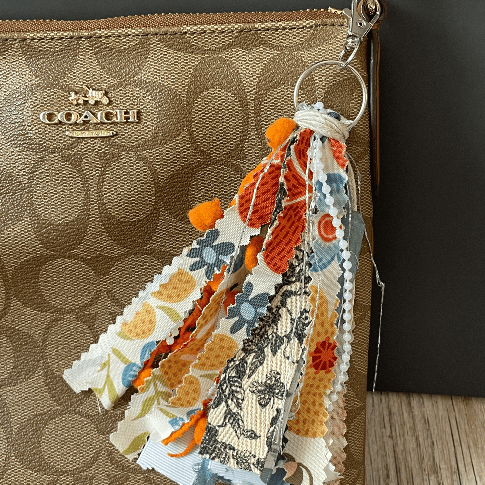 Orange and floral tassel on purse.