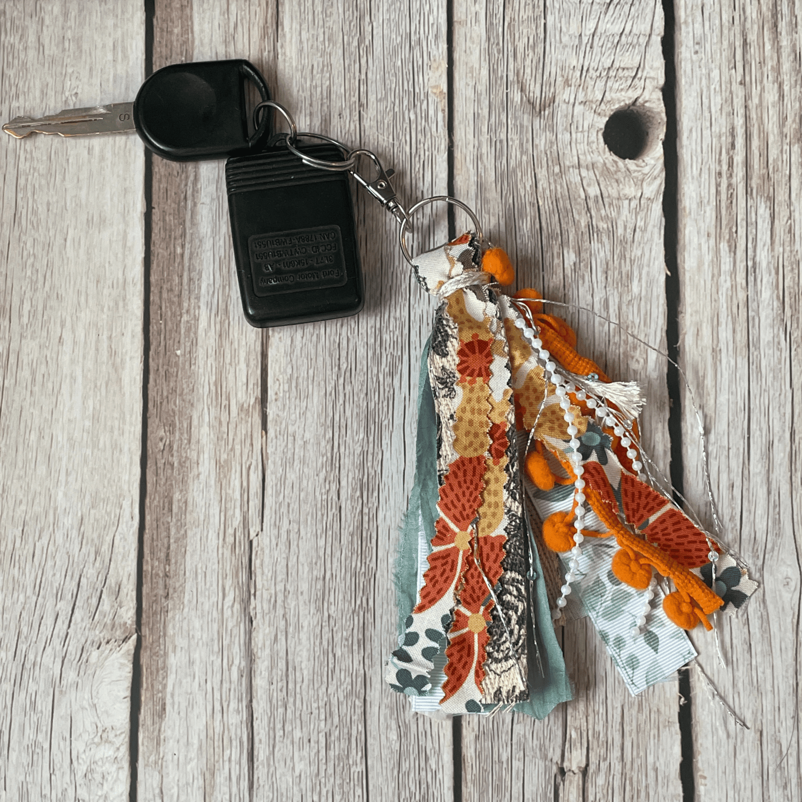 orange and floral tassel keychain on keys