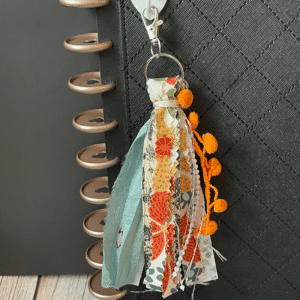 orange and floral tassel keychain on journal